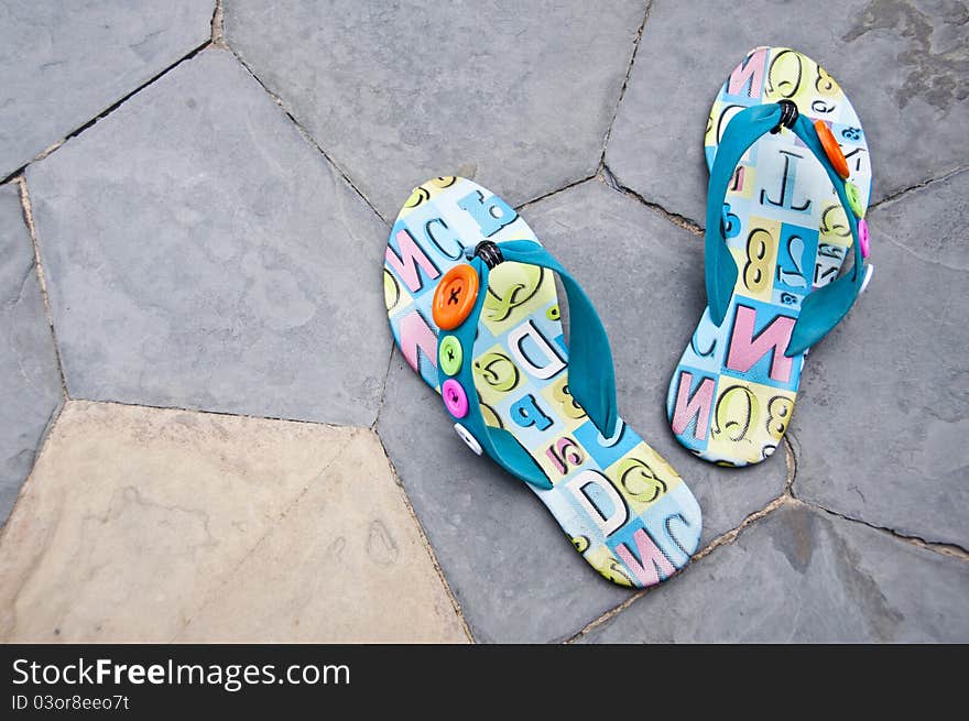 Colorful sandals on the floor near swimming pool. Colorful sandals on the floor near swimming pool.