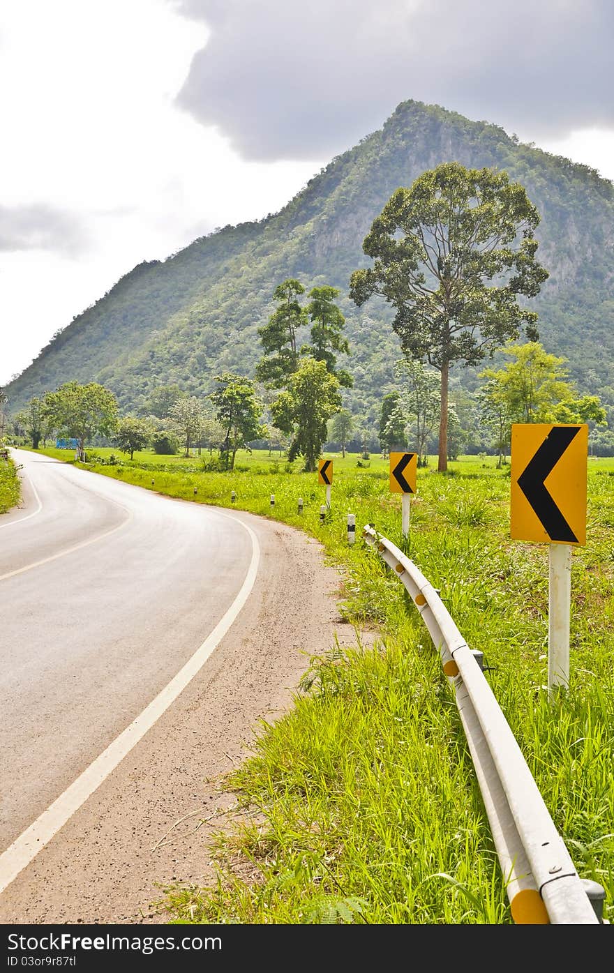 Country road with curve sign in sunny day. Country road with curve sign in sunny day.