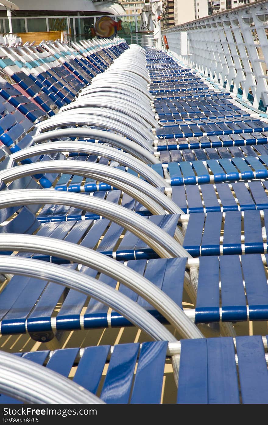 Many beach chairs in a long row on a cruise ship