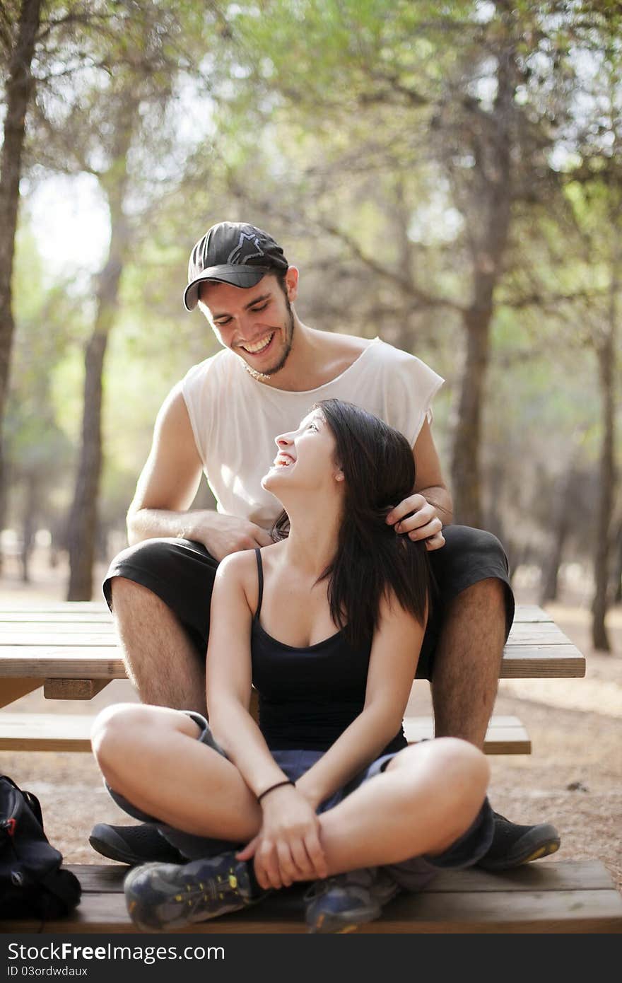 Young happy couple smiling each other in the forest. Young happy couple smiling each other in the forest.