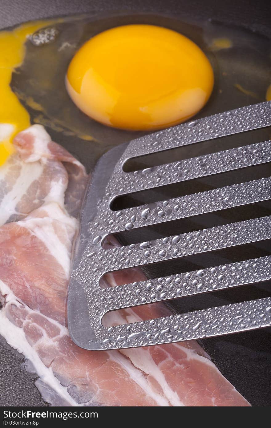 Studio-shot of preparing breakfast in a frying pan with ham and fried eggs