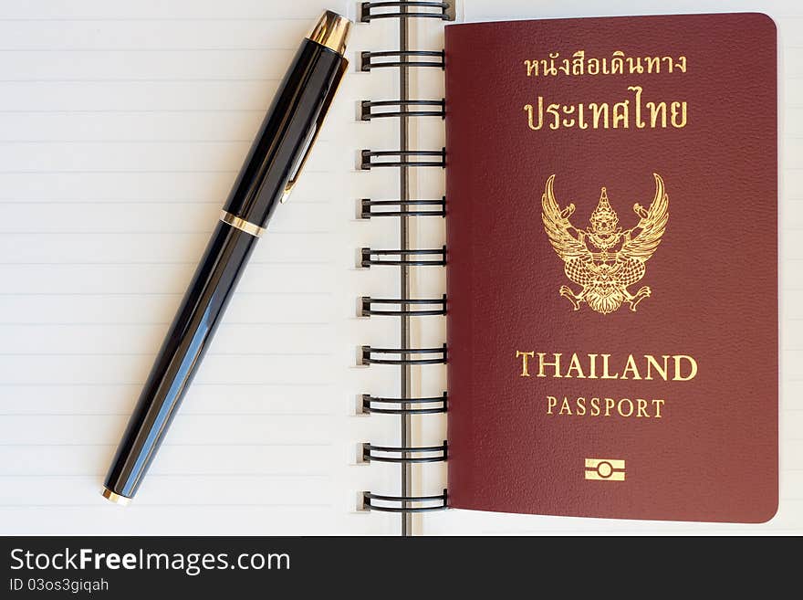 Thailand passport and pen on blank page in a spiral bound notebook