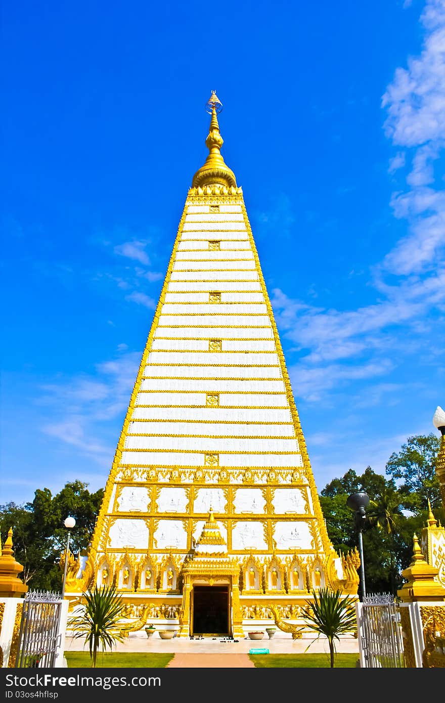 Thai white pagoda in the front view with blue sky and white cloud. Thai white pagoda in the front view with blue sky and white cloud