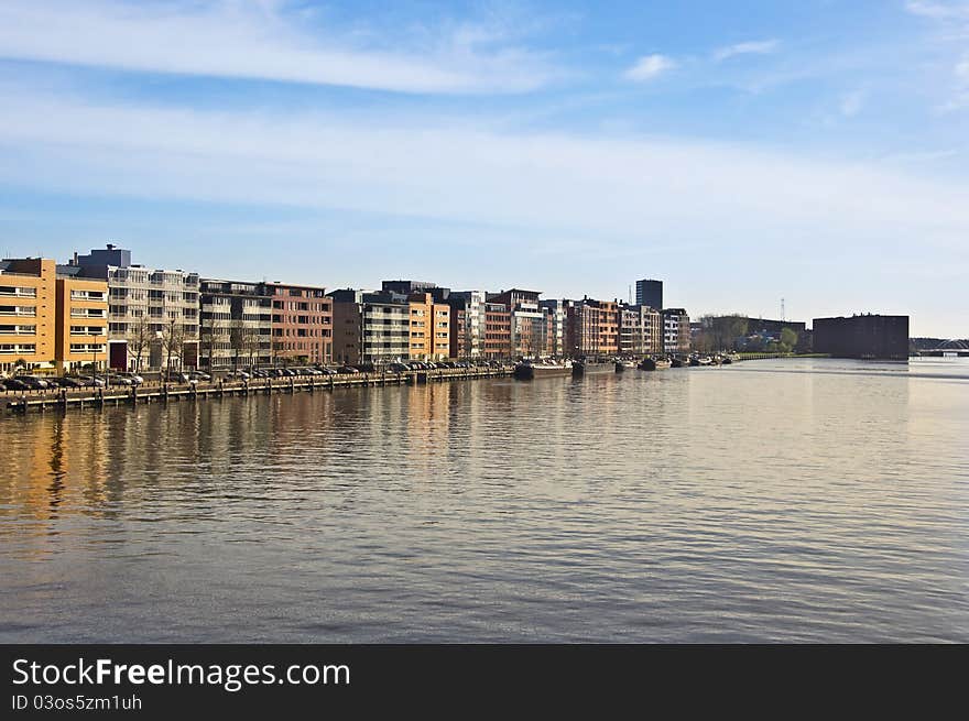 Modern architecture in Amsterdam. Island of Borneo. Modern housing is reflected in the water against the blue sky.