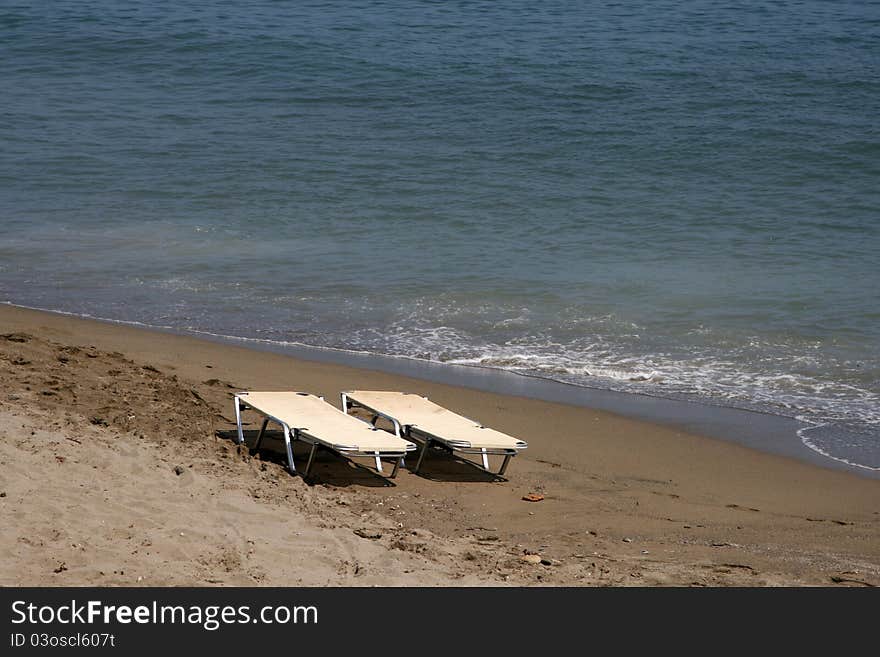 Two white seabeds on the sand for sunbathing