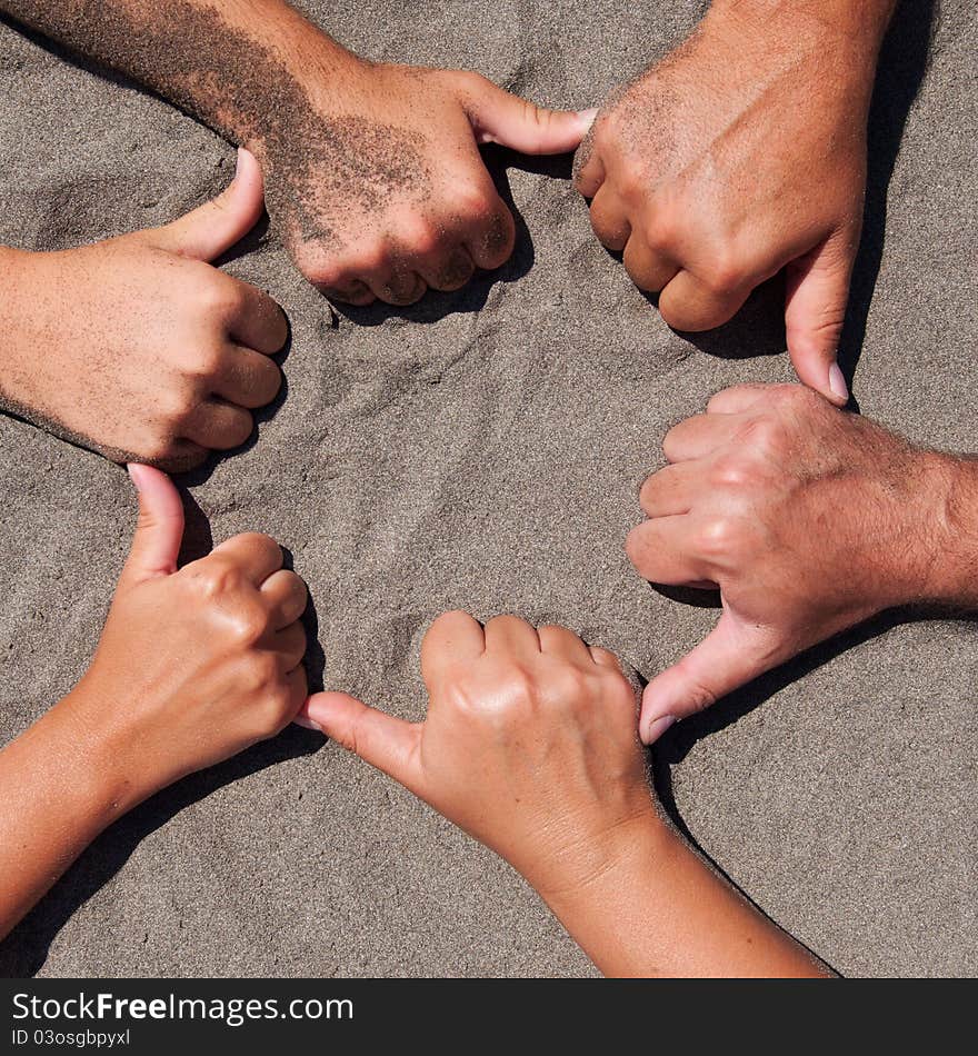 Image of hands on sand - circle form