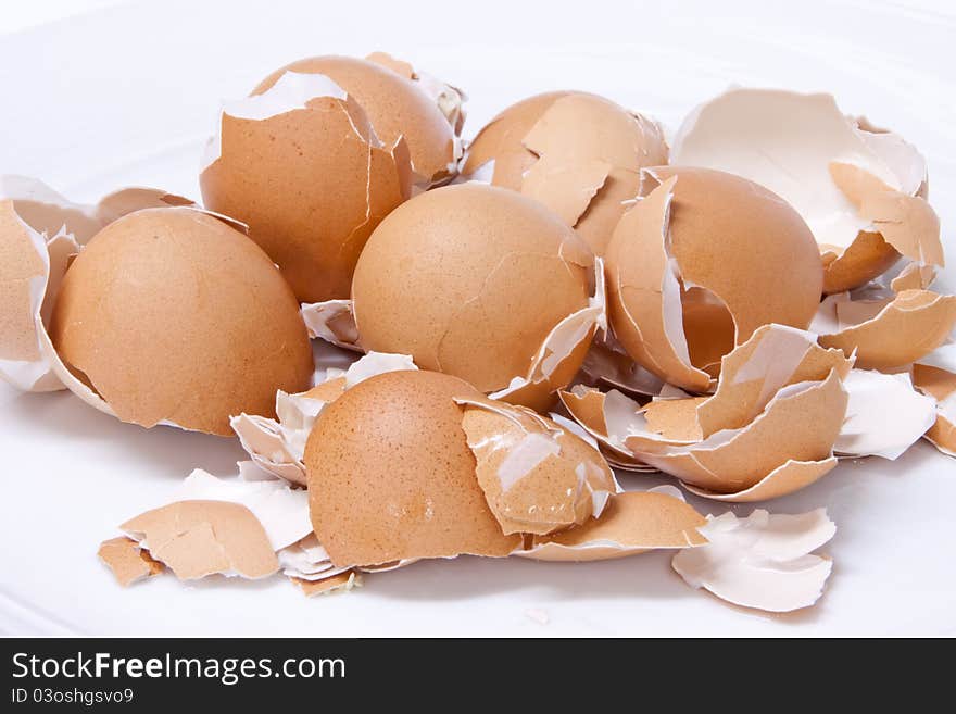 Eggs shell scattered on a white background