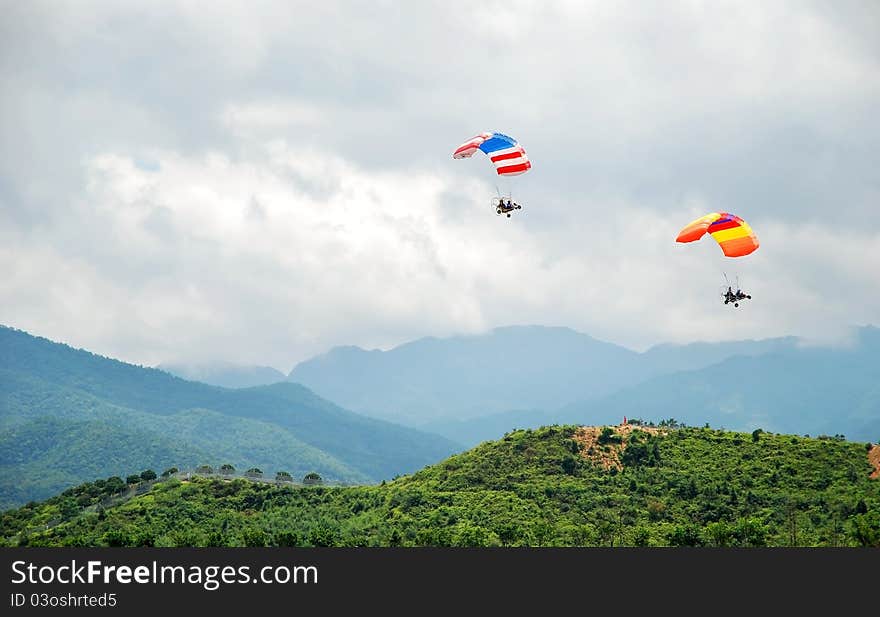 Two powered parachutes over the mountains.