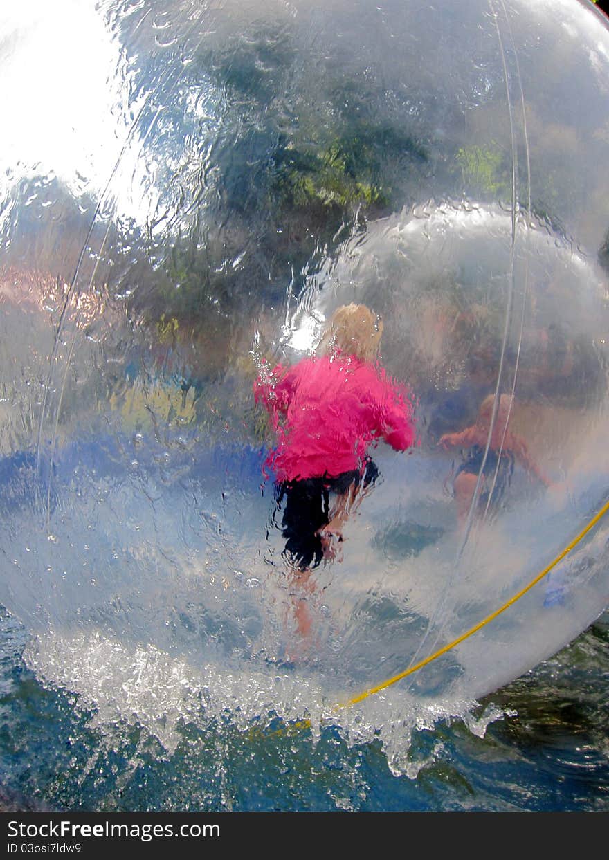 Two children playing in big balloons so-called waterbubbles