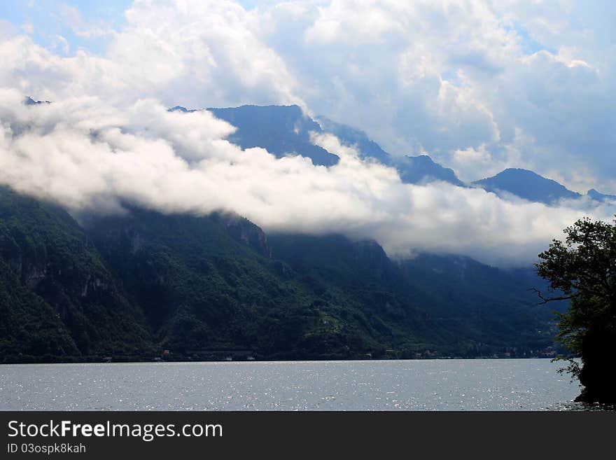 Cock clouds laying down over mountain at Como lake, Italy. Cock clouds laying down over mountain at Como lake, Italy