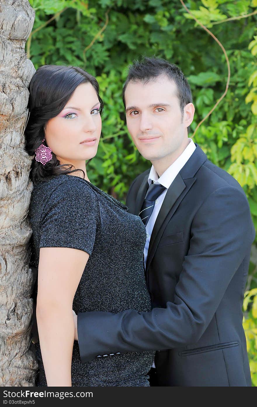 Boy and girl embracing gently around a tree. Boy and girl embracing gently around a tree