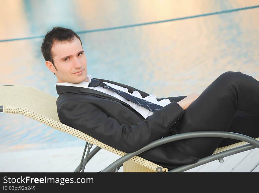 Attractive young man lying beside a pool. Attractive young man lying beside a pool