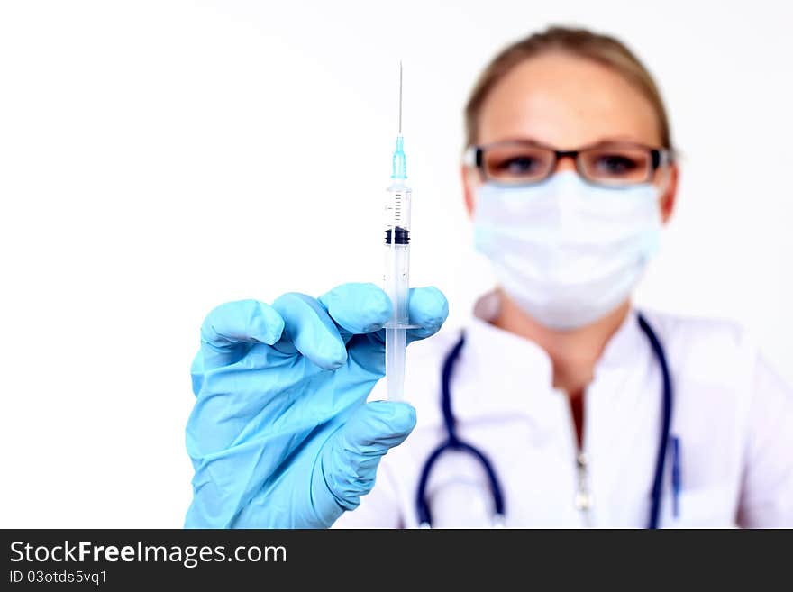 Young female doctor in white uniform wearing mask and gloves with syringe. Young female doctor in white uniform wearing mask and gloves with syringe