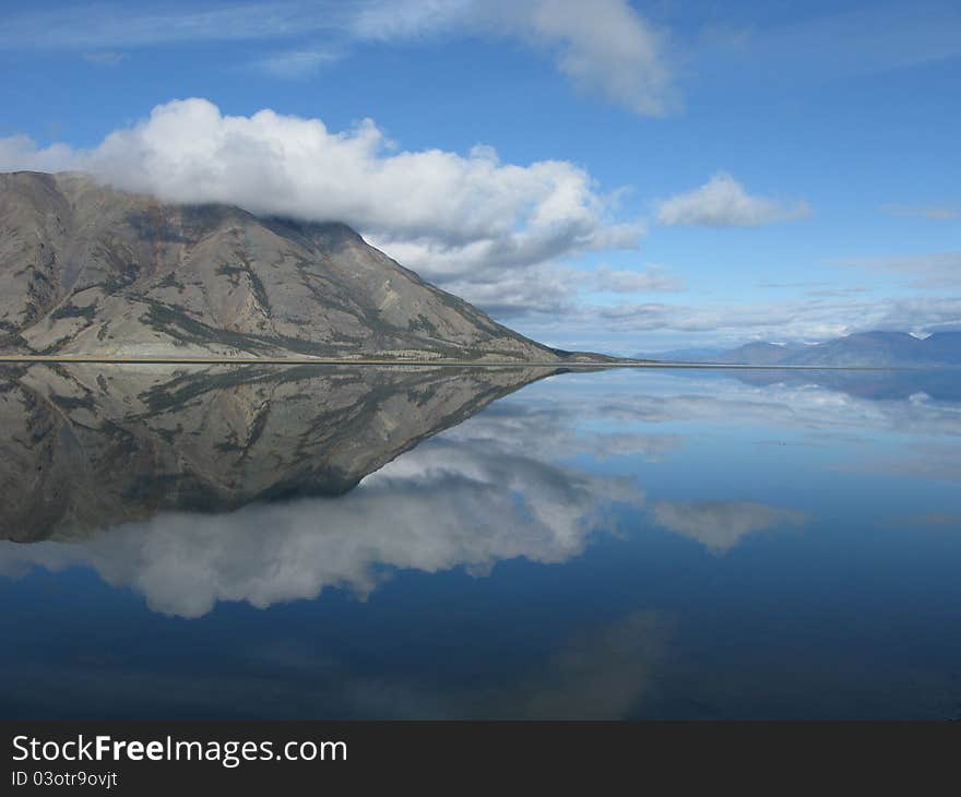 Perfect reflection on a peaceful lake near the Alaska Highway in the Yukon Territory. Perfect reflection on a peaceful lake near the Alaska Highway in the Yukon Territory