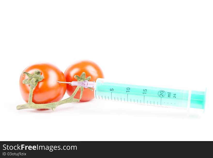 Tomatoes and syringe isolated of a white background. Tomatoes and syringe isolated of a white background