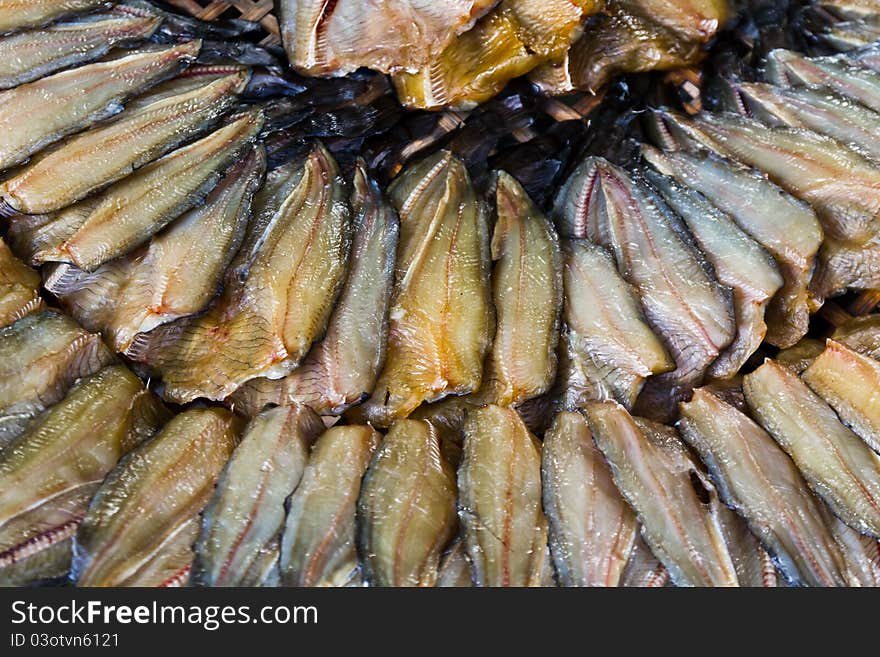 Dried fish in a circle on plate.