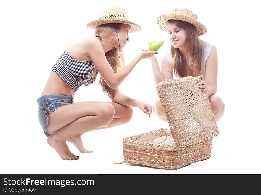 Two girls in straw hats with a straw suitcase, studio photography