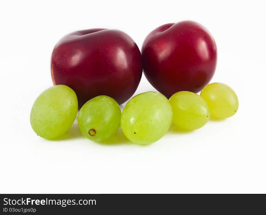 Plums and grapes on white background