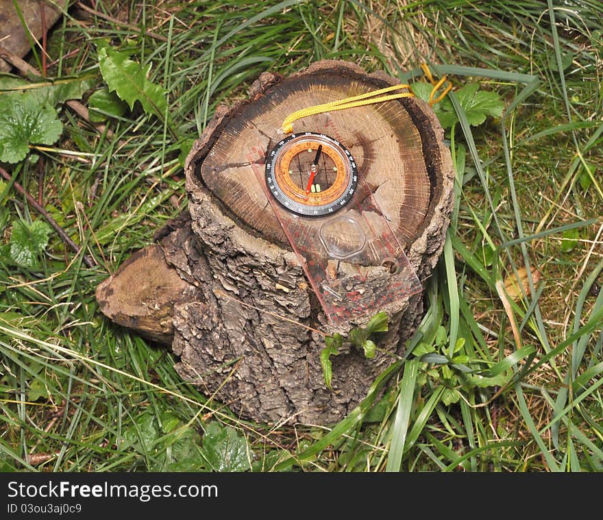 The compass lies on the foozle in wood. The compass lies on the foozle in wood