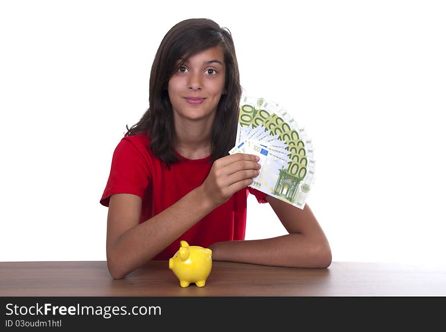 Brunette teen girl with piggy bank and bills of 100 euros on white background