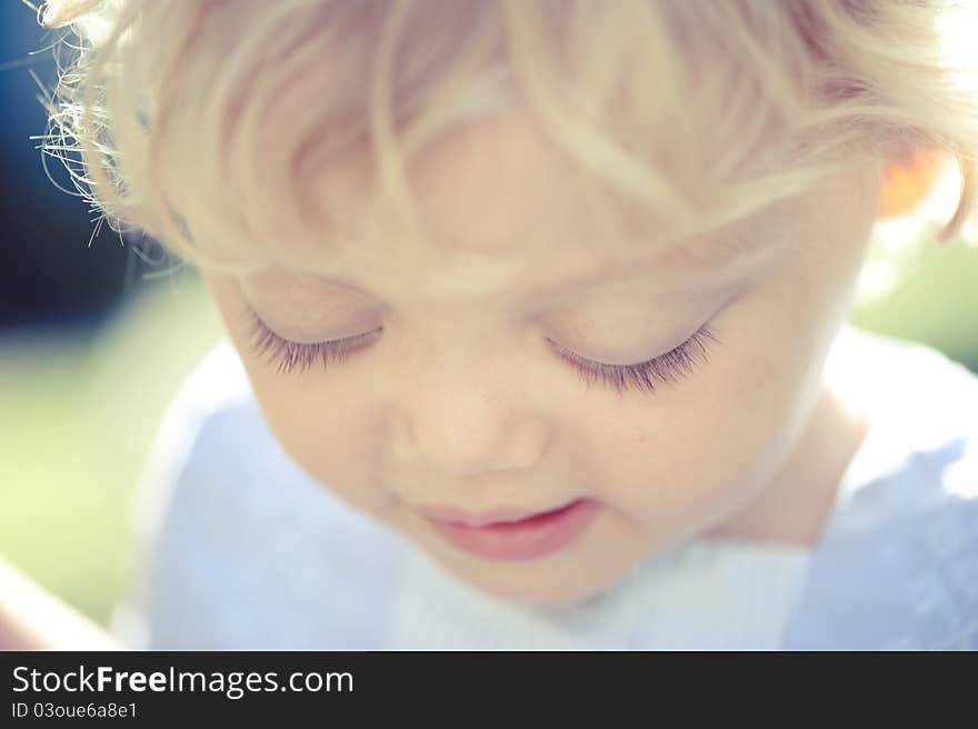 Close-up portrait of a little girl looking down