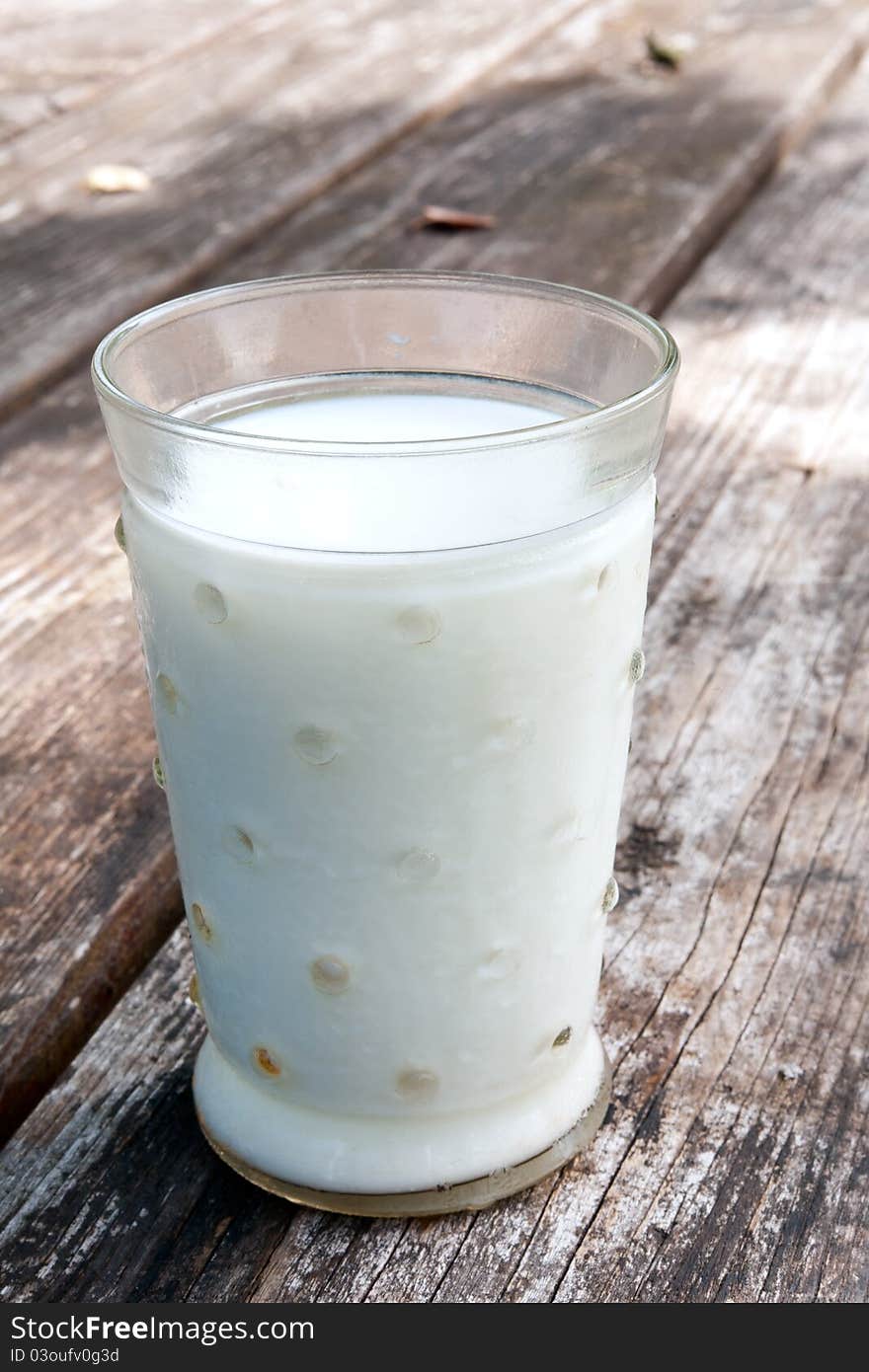 Glass of milk closeup on a wooden table