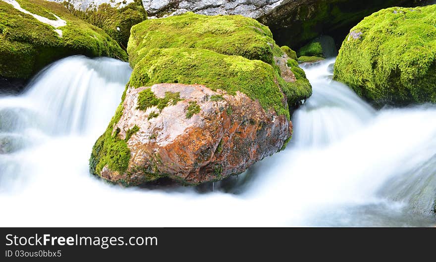 Long exposure image of a mountain stream flowing trough stone. Long exposure image of a mountain stream flowing trough stone.