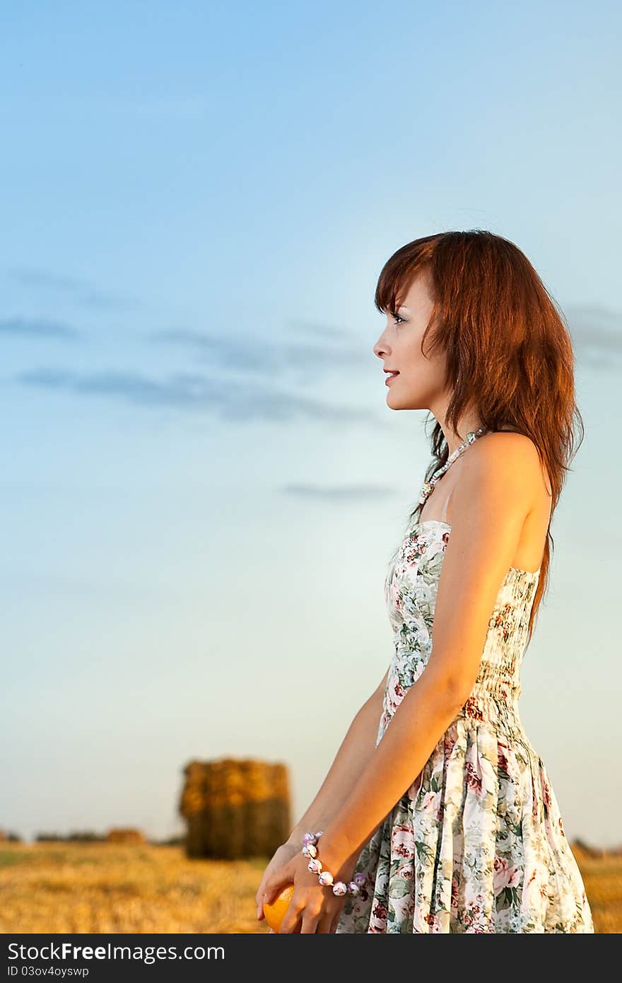 Portrait of the girl in the field in solar weather