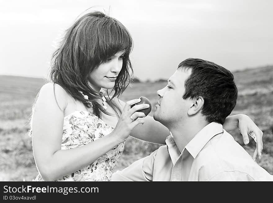 The wife feeds the husband in the field. The wife feeds the husband in the field