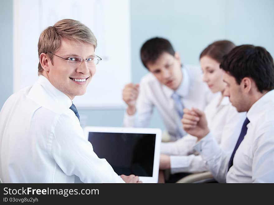 A young man with a laptop in the office. A young man with a laptop in the office