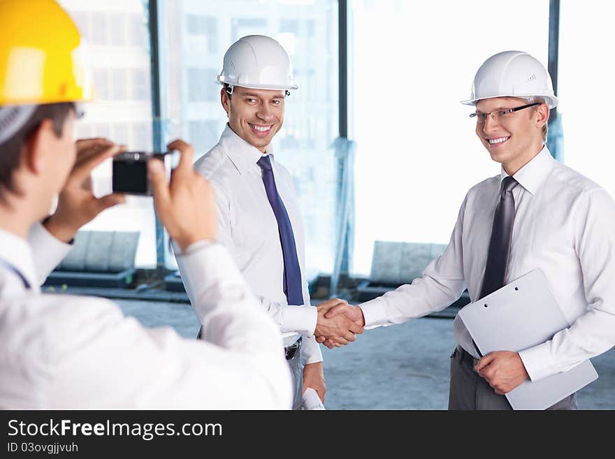 A man photographed handshake business partners in construction. A man photographed handshake business partners in construction