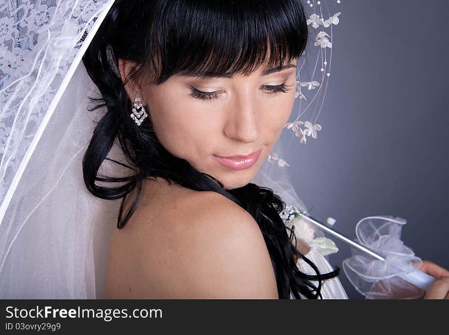 Romantic portrait of the bride's close-up, with an umbrella.