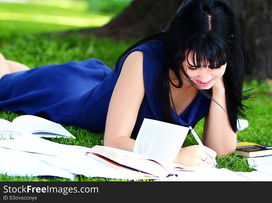 Beautiful student girl studying in green park. Beautiful student girl studying in green park