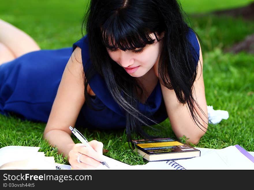 Beautiful student girl studying in green park. Beautiful student girl studying in green park