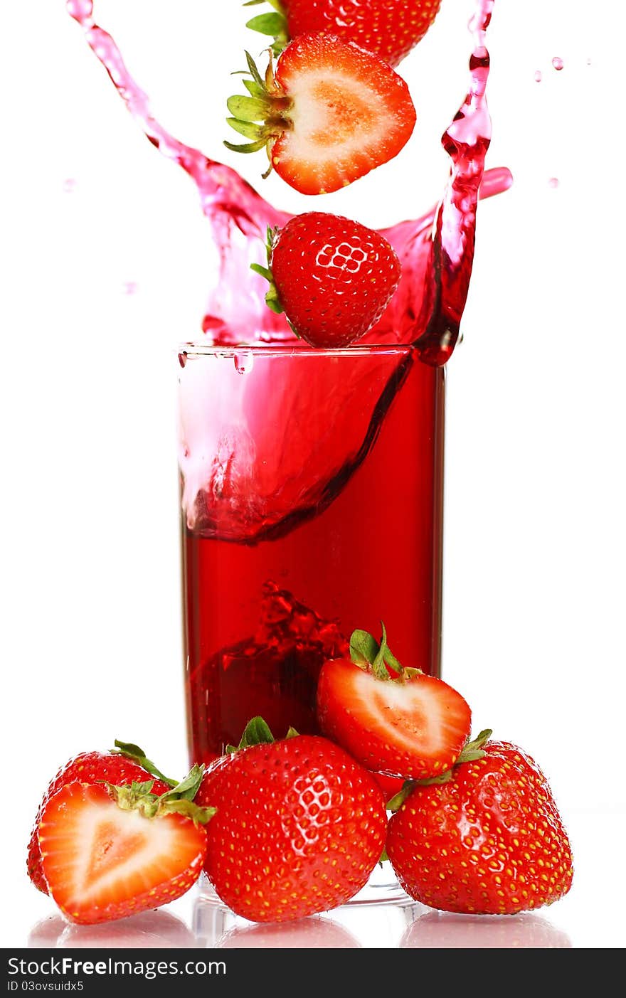 Strawberry falling into the glass with drink and makes big splashes