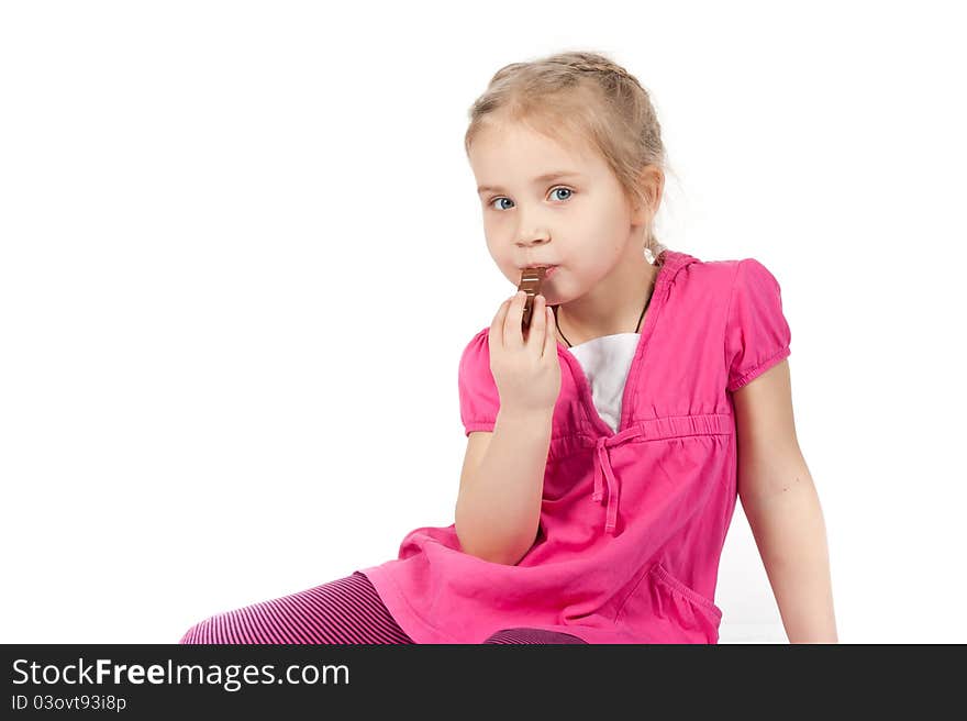 Beautiful girl eating chocolate bar on white background