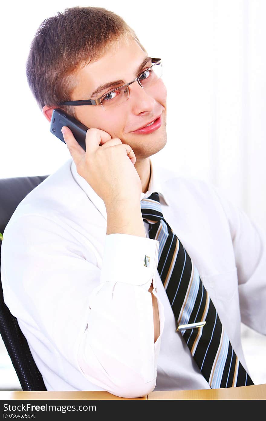 Young smiling businessman using cell phone