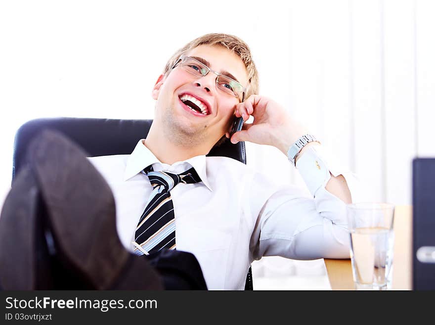 Young smiling businessman using cell phone