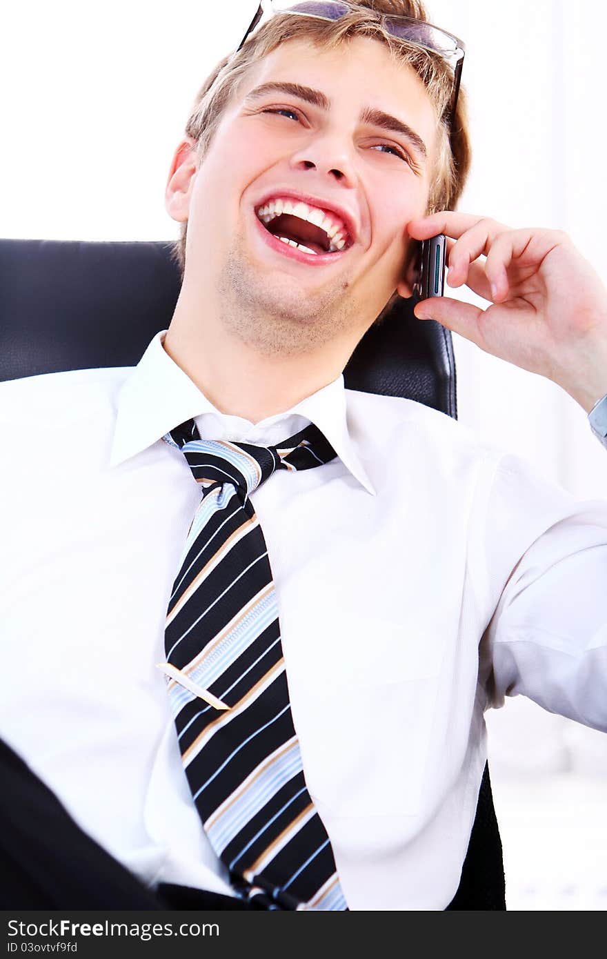 Young smiling businessman using cell phone