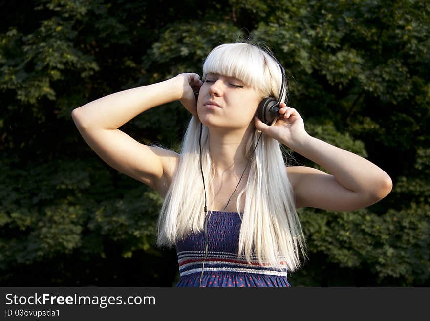 Adult girl listening to the music outdoors