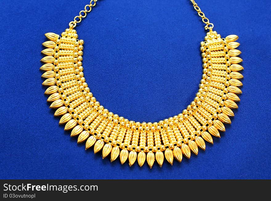 Golden neclace on blue background