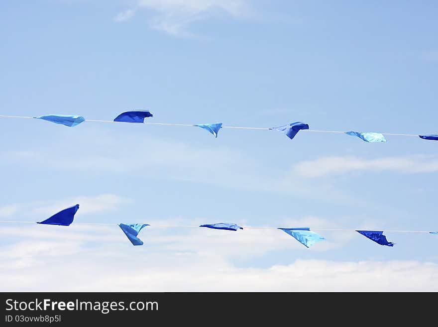 Colourful flags blowing in the wind under a bright blue sky