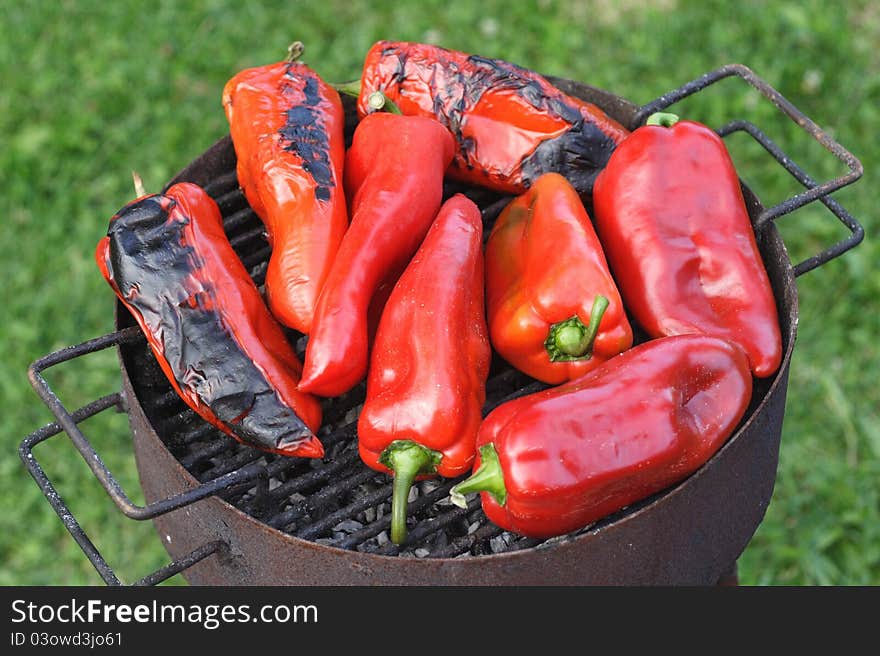 Red peppers being grilled over an outdoor barbeque. Red peppers being grilled over an outdoor barbeque