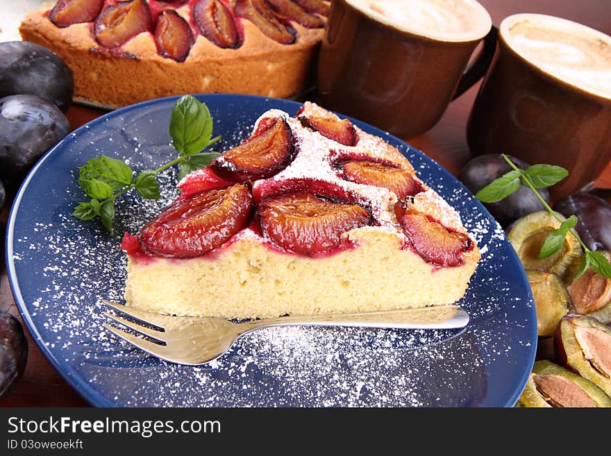 Plum pie, coffee and plums on a wooden background. Plum pie, coffee and plums on a wooden background