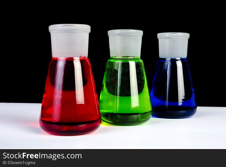 3 colors chemicals in laboratory glassware in a row. 3 colors chemicals in laboratory glassware in a row