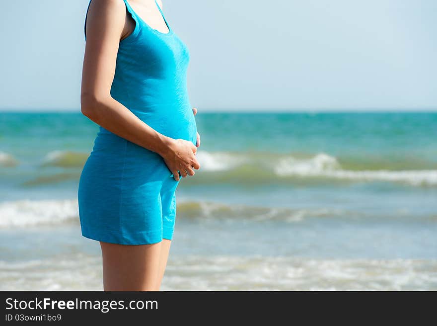 Woman Is Holding Pregnant Belly On The Beach