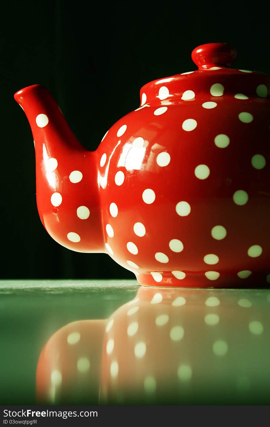 Detail of red and white dots teapot on table