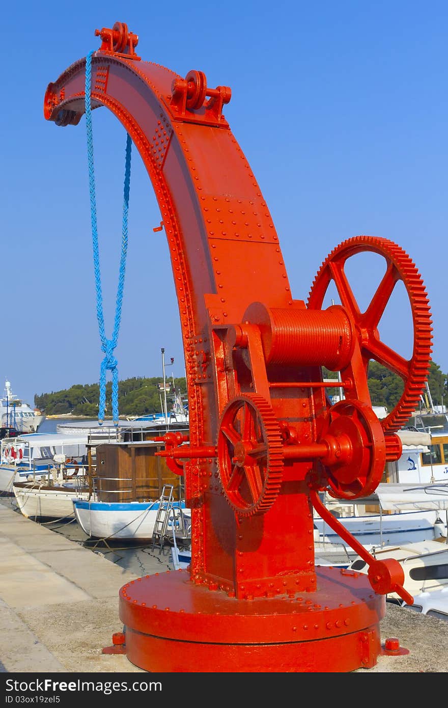 Little red crane for lifting vessels in port