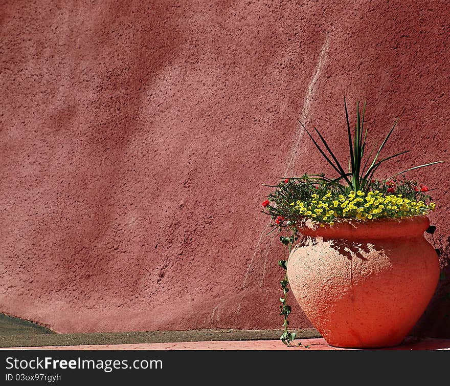 Adobe Pottery with Flowers next to an adobe wall in the Manitou Springs Cliff Dwellers park. Adobe Pottery with Flowers next to an adobe wall in the Manitou Springs Cliff Dwellers park.