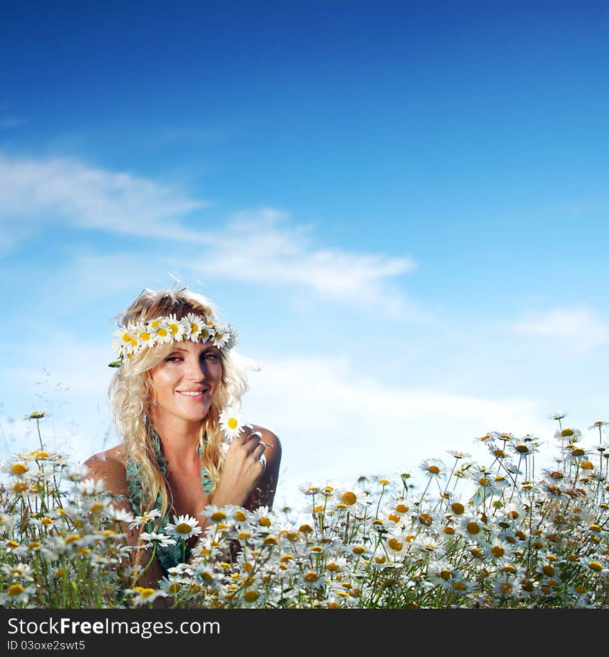 Beautiful girl on the daisy flowers field